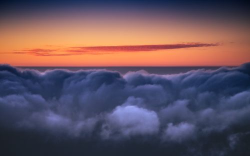 Free Stunning aerial view of a colorful sunset above fluffy clouds in Santa Cruz de Tenerife. Stock Photo