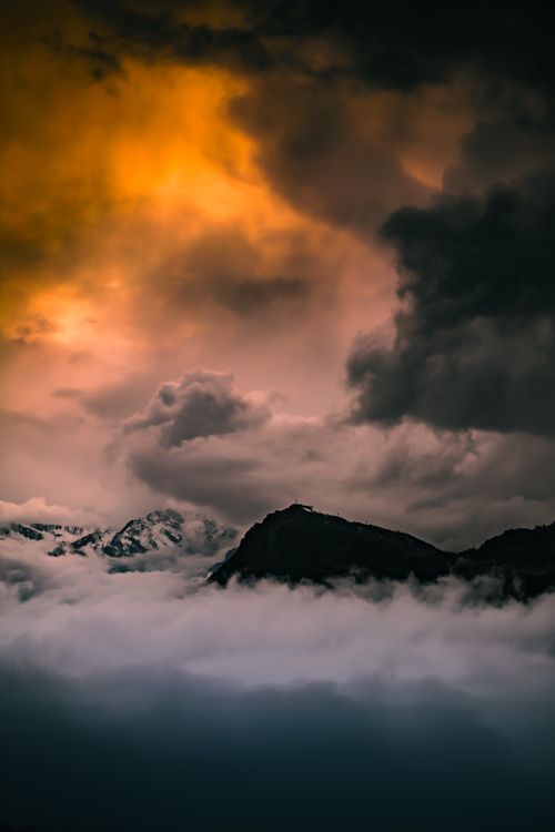 Free Epic scene of cloudy sunset over misty mountains in Italy, creating a dramatic atmosphere. Stock Photo