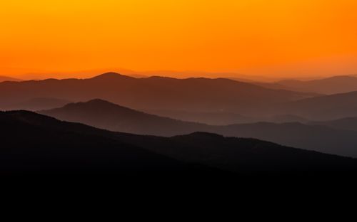 Free Stunning sunrise with vibrant orange hues over mountain silhouettes in Podkarpackie Voivodeship, Poland. Stock Photo