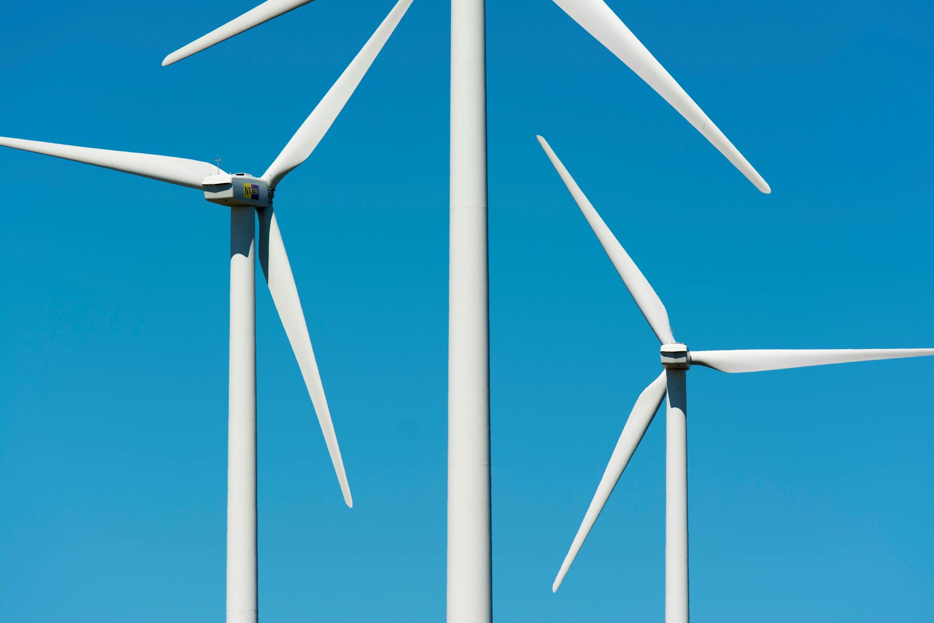 Close-up view of wind turbines generating clean energy against a clear blue sky.