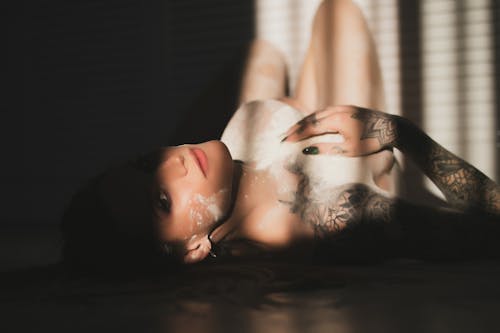 Naked Woman With Tattoo Lying on Floor