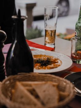 A warm dining setting featuring beer, a plated meal, and tableware in a restaurant ambiance.
