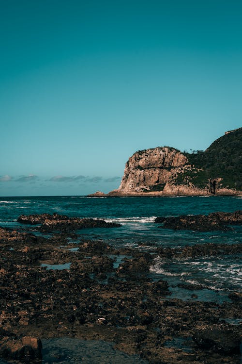 A Rock Formation on Sea Under Blue Sky