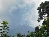 Smoke billows from an erupting volcano in Indonesia, showcasing nature's power.