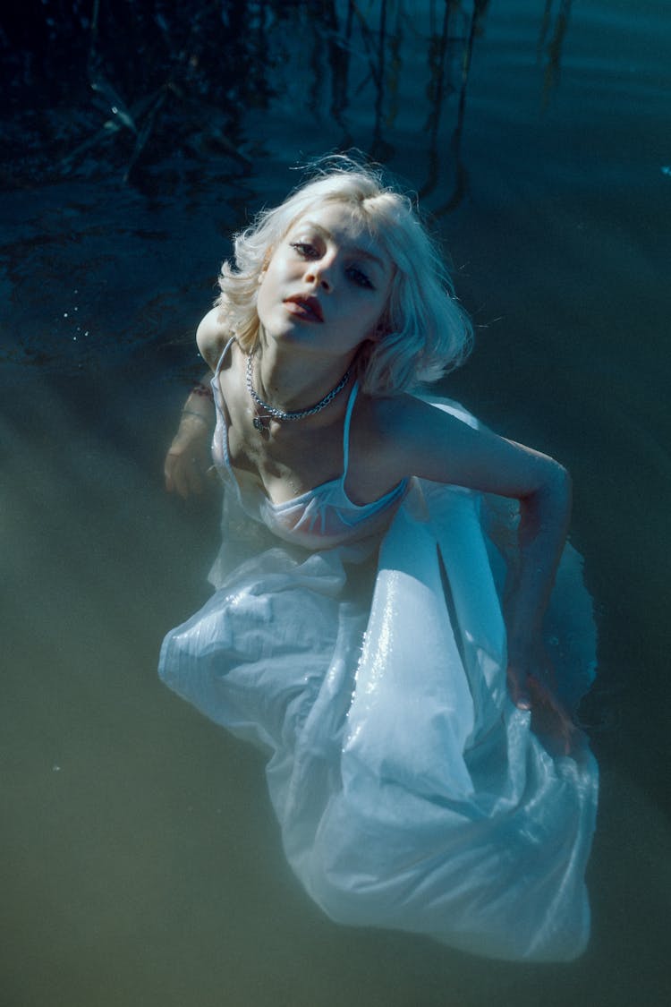 Serene Young Woman In Maxi Dress Swimming In Lake