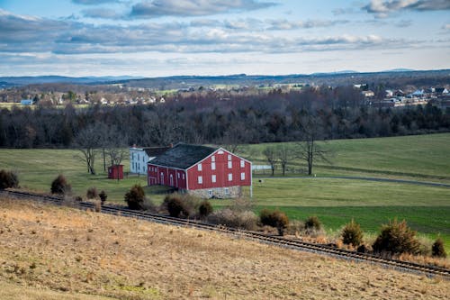 Red And Grey House In The Middle Of Green Grass Field