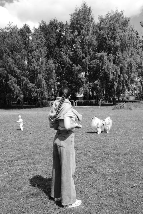 Grayscale Photo of a Woman Standing on Grass