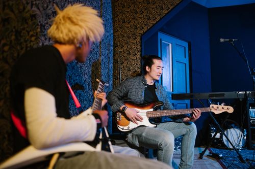 Free Two musicians playing guitar and bass in an indoor studio setting. Stock Photo