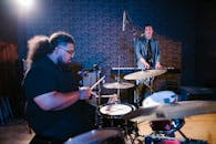 Man in Blue Polo Shirt Playing Drum