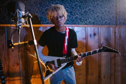 Free A young adult playing an electric guitar in a cozy indoor studio setting with professional equipment. Stock Photo