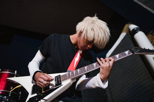 Blond musician passionately playing an electric guitar at an indoor rock concert.