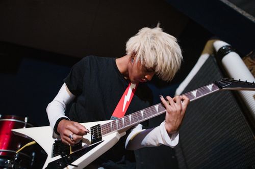 Free Blond musician passionately playing an electric guitar at an indoor rock concert. Stock Photo