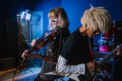 Man Playing an Electric Guitar and Woman Playing the Violin 