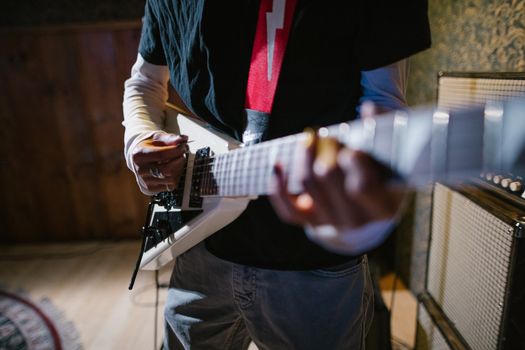 Close-up of a musician playing an electric guitar indoors, focus on hands and instrument.. pexels, close, musician
