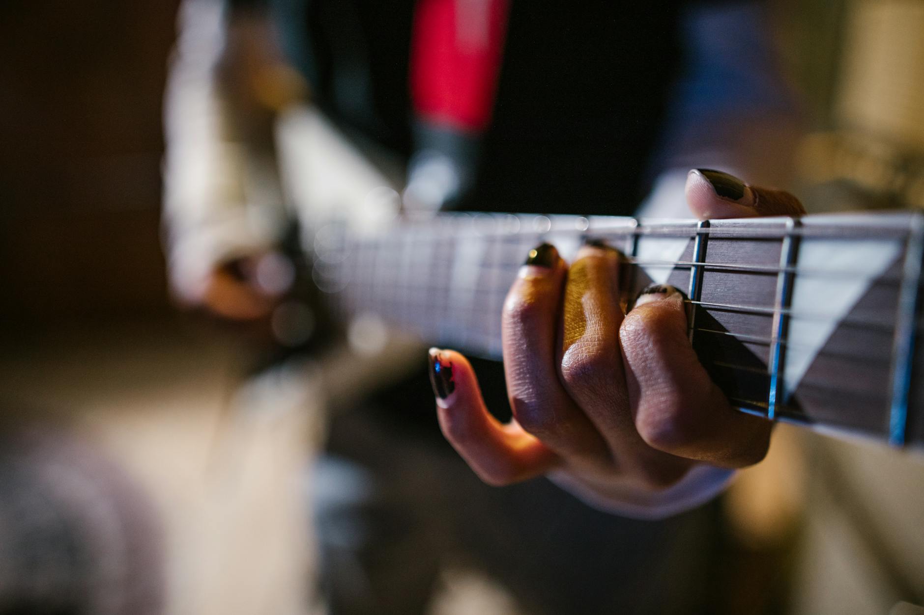 Focused hands of a musician strumming an electric guitar in a dynamic music appr