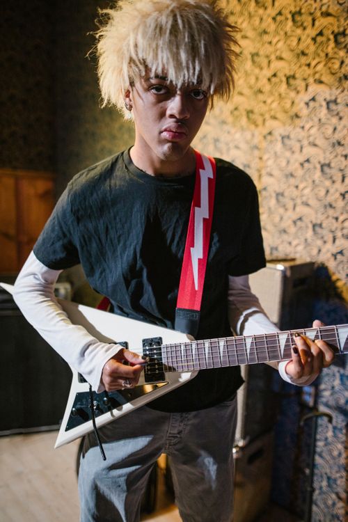 Free A young musician passionately practicing with an electric guitar indoors. Stock Photo