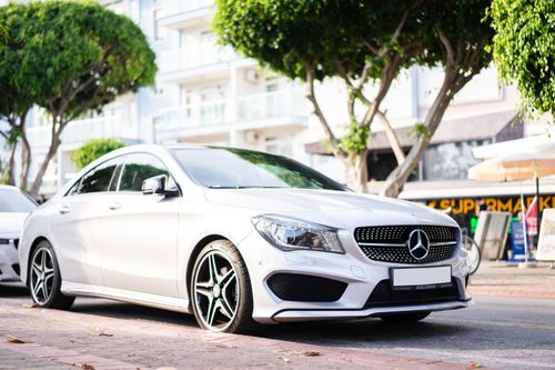 Free Elegant white Mercedes Benz car parked on a sunny urban street. Stock Photo