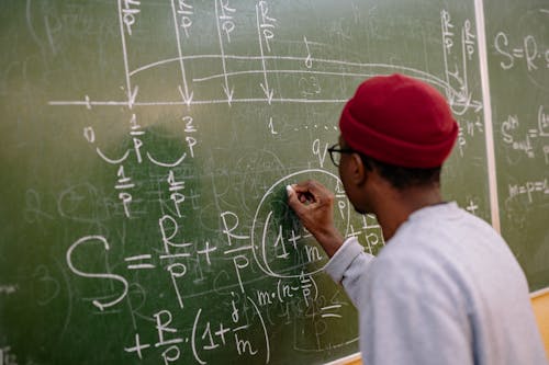 Free Back View of a Student Answering a Problem on the Chalkboard Stock Photo
