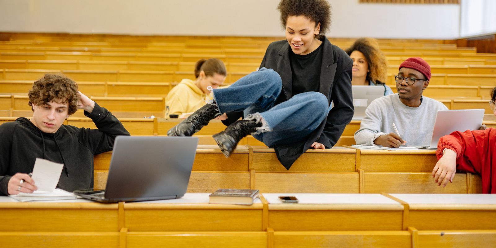 Diverse students interact and study in a university lecture hall.
