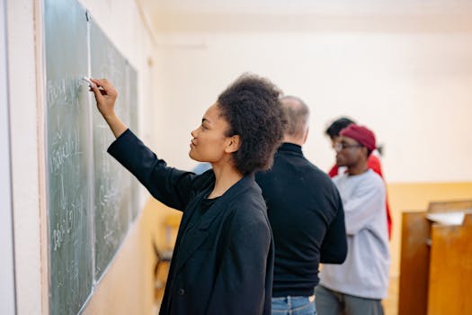 A young student writing on a blackboard in a classroom, showcasing a learning environment.