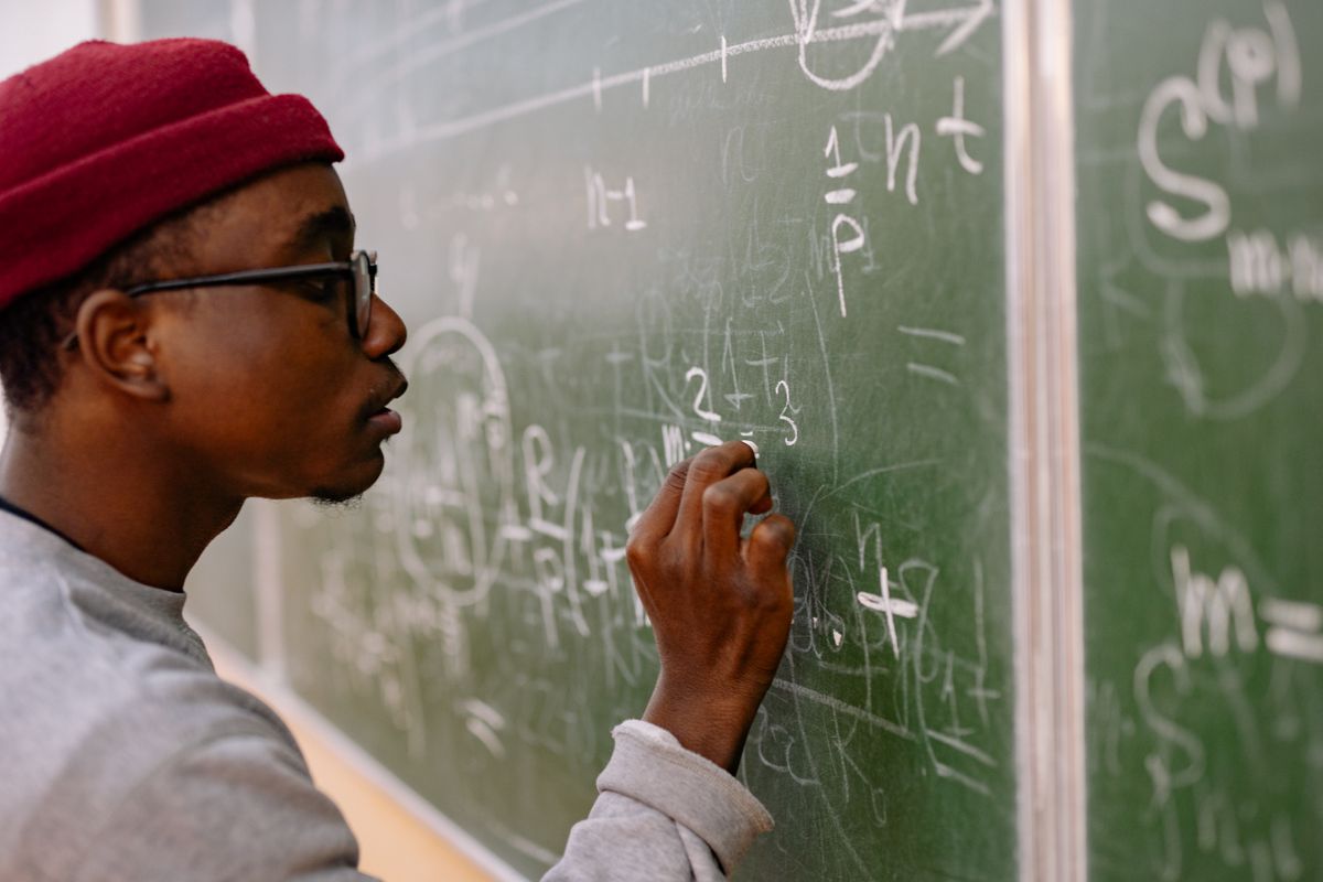 Teacher writing on a chalkboard during a language lesson