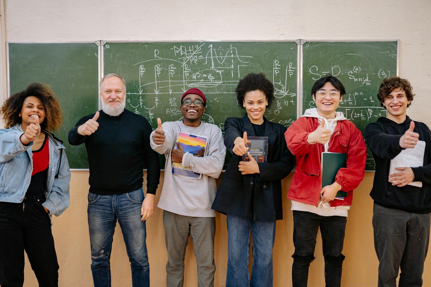Diverse group of students with teacher showing success