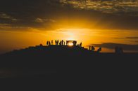 Silhouette of People Standing on Beach during Sunset