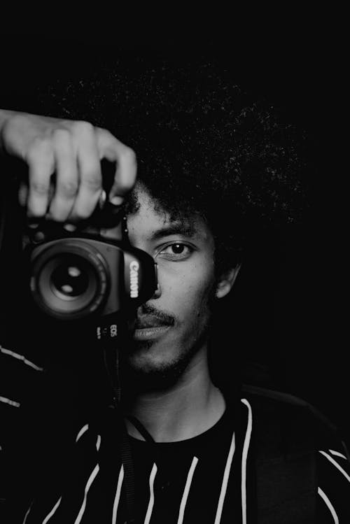 Black and White Photo of a Photographer Holding a Camera