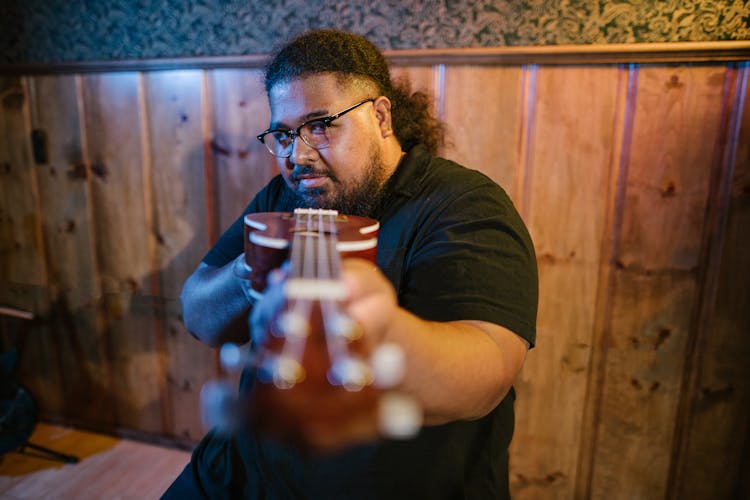 A Man Holding A Ukelele