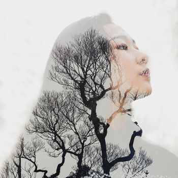 这幅创意双重曝光作品以女人和树枝为特色，融合了自然与肖像艺术