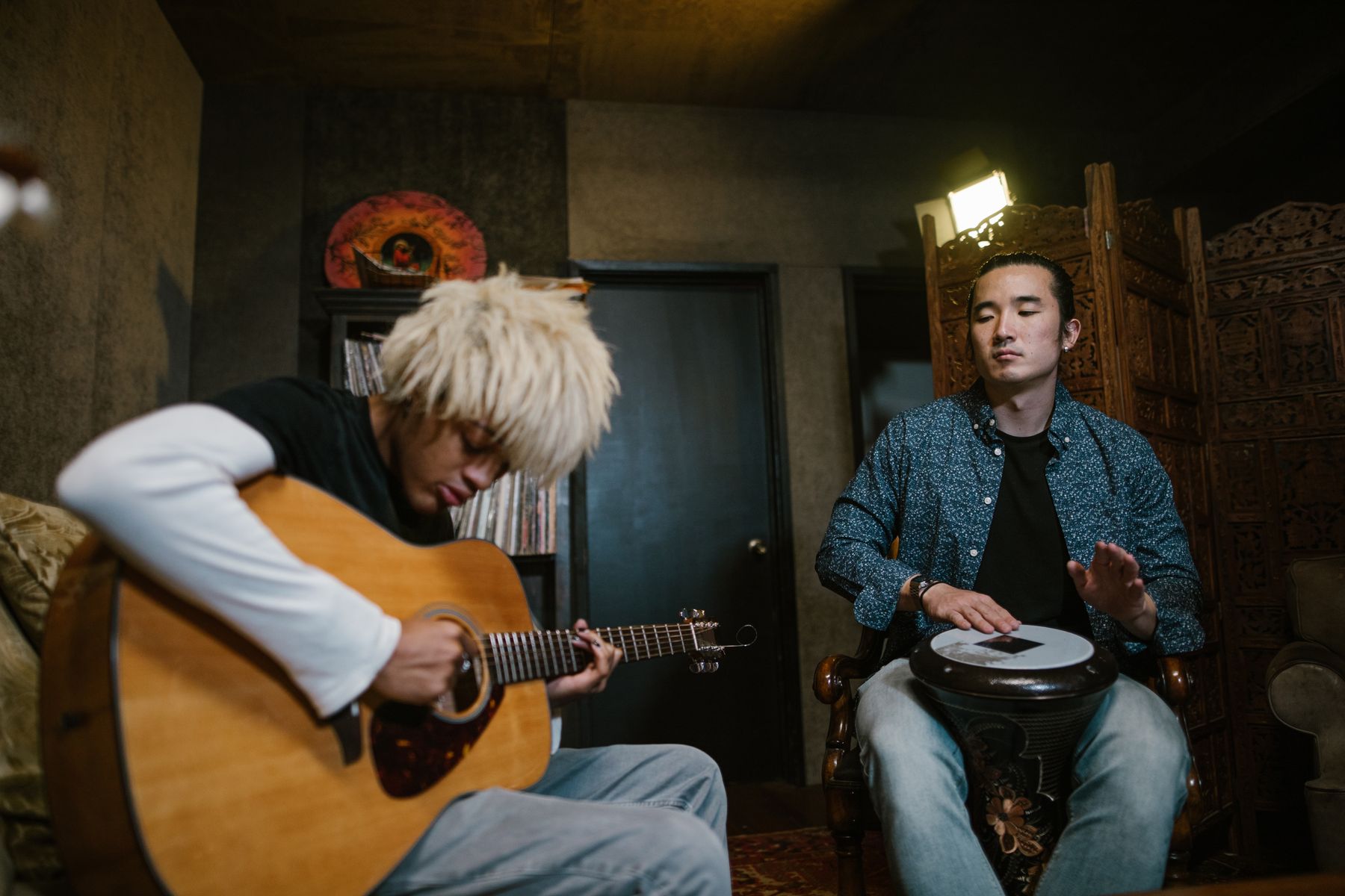 Two musicians sharing a candid moment with guitar and percussion