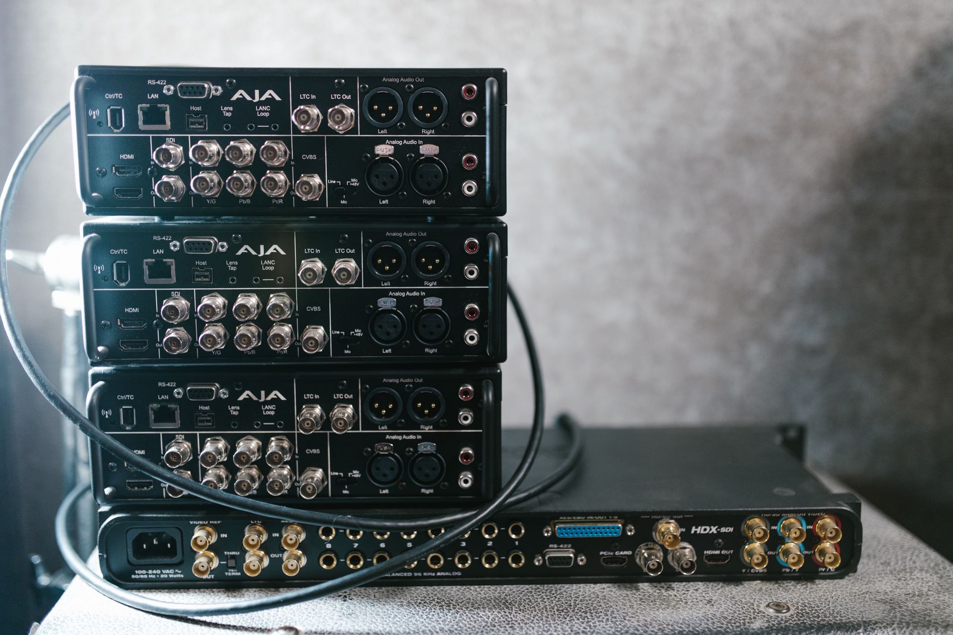 Stacked professional audio video equipment with multiple connectors for recording studio settings.