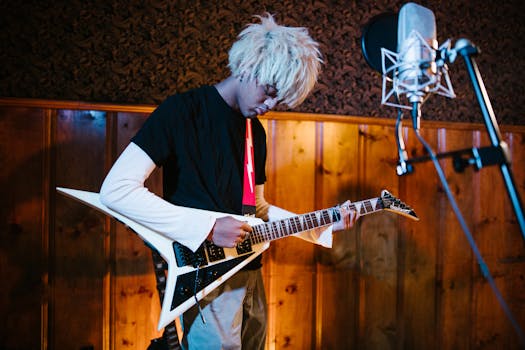 A young musician playing an electric guitar in a music studio setting.