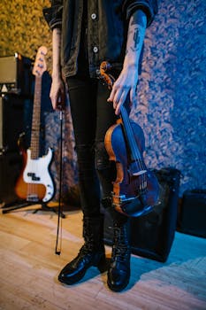Close-up of a musician holding a violin in a modern studio. Warm and inviting atmosphere.