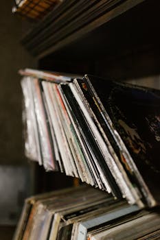 Close-up of a collection of vintage vinyl records neatly stacked on a shelf in a music studio.