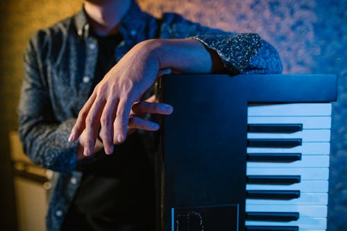 Close-up of Man Leaning against a Piano 