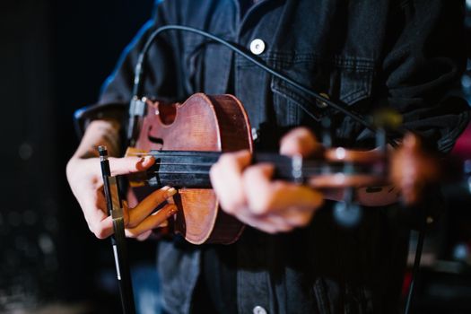 A musician passionately plays the viola on stage, capturing the essence of live performance.