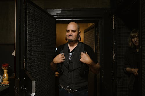 A Man Wearing a Black Vest Over a Black Shirt