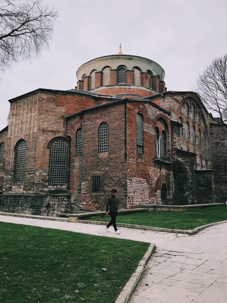 A Man Walking Outside Of A Museum