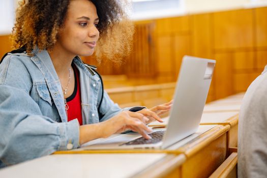 Close-Up Shot of a Curly-Haired Woman in Blue Denim Jacket Using a Laptop
