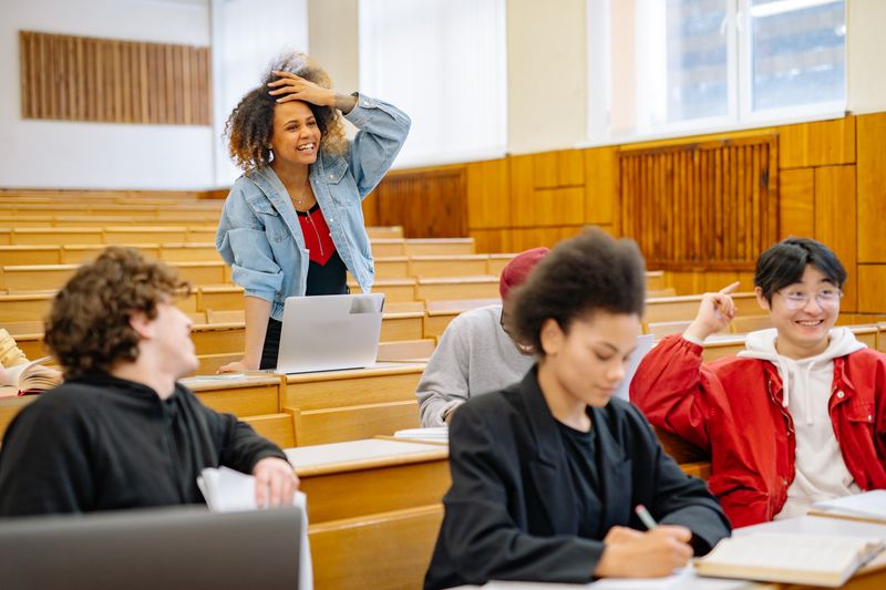 Estudiantes interactuando en aula universitaria