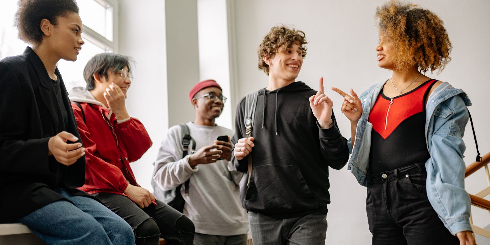 A lively group of friends enjoying a conversation indoors, highlighting diversity and connection.
