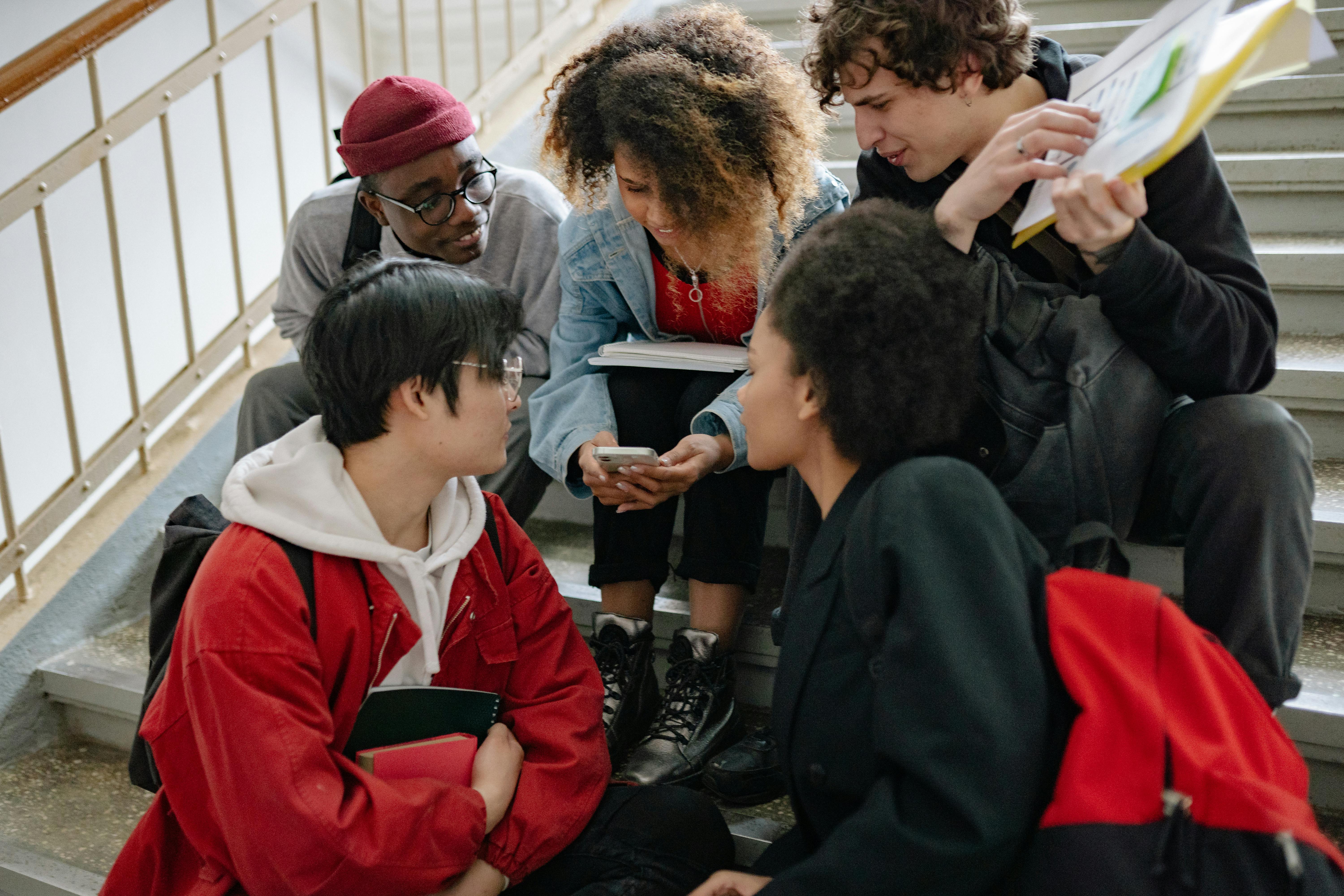 a group of people looking on a smartphone