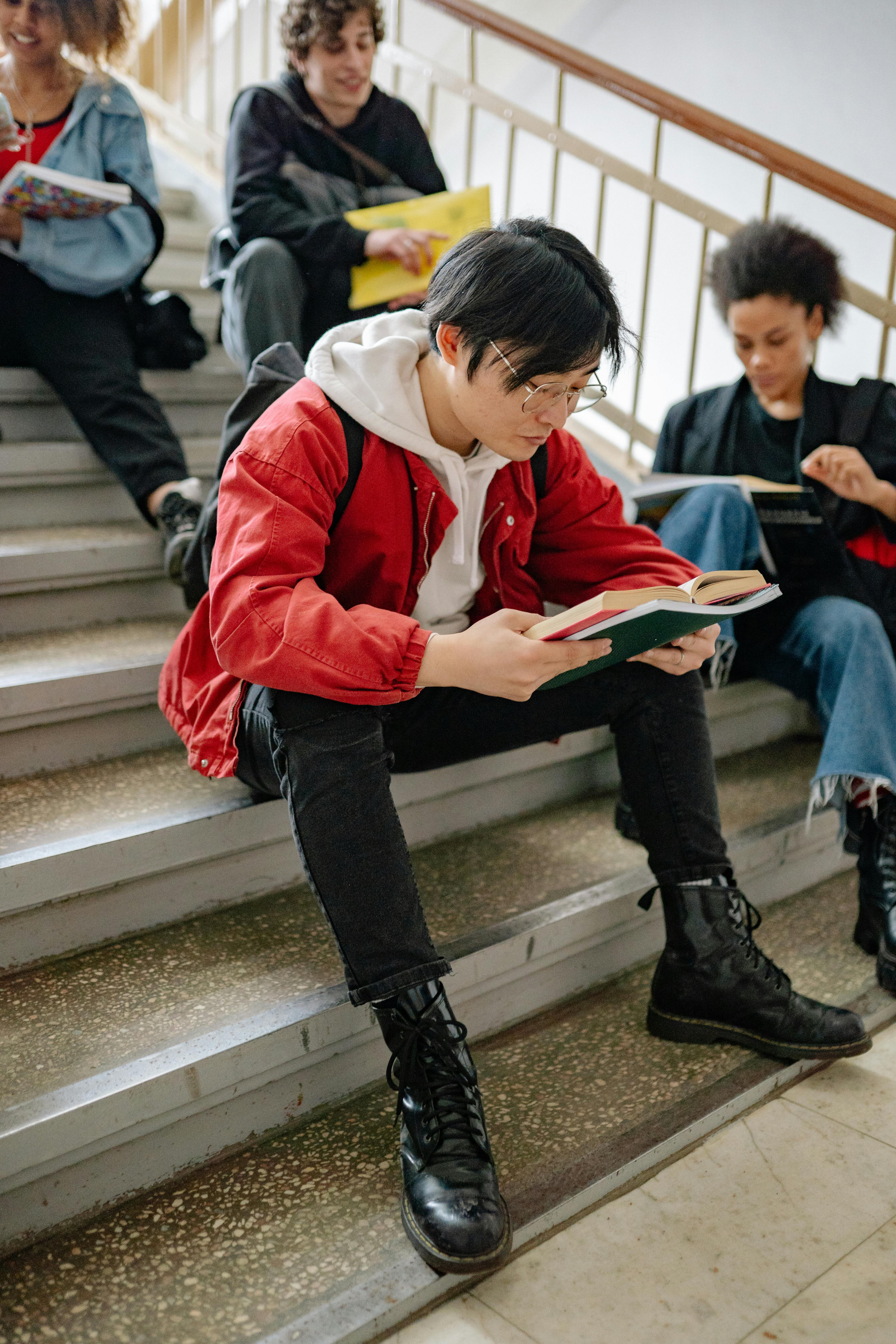 students reading while sitting on the stairs