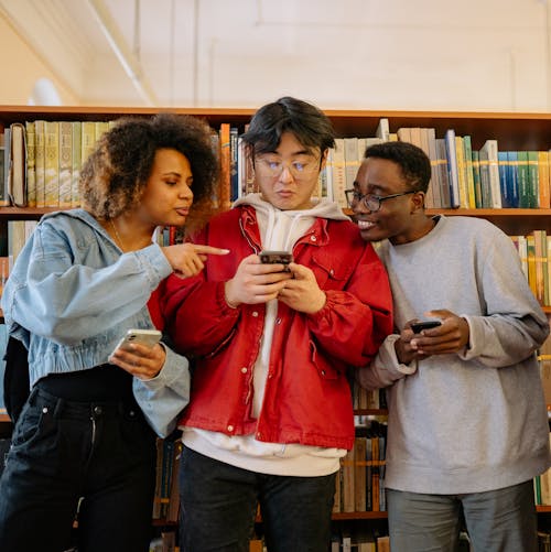 Free 
Students Using Their Smartphones in a Library Stock Photo