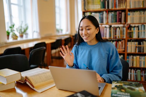 Woman in Blue Long Sleeve Shirt doing Videocall