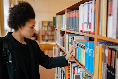 Foto profissional grátis de aluno, biblioteca, dentro de casa