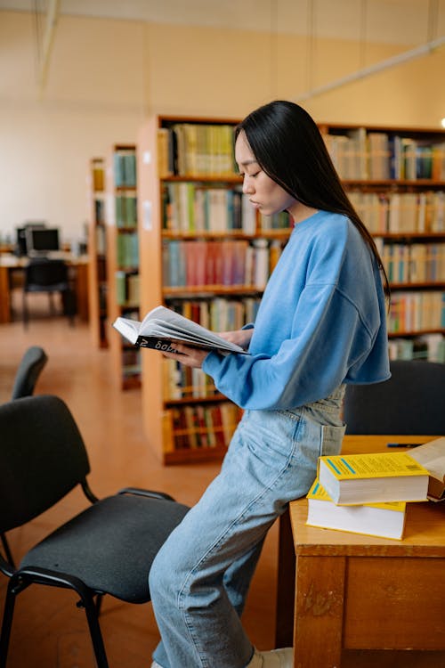 Woman in Blue Long Sleeve Shirt Reading Books