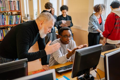 A Teacher and a Boy in Front of a Computer