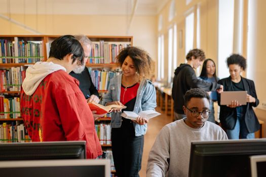 Students collaborating and studying in a library, fostering education and diversity.